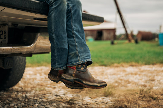 American flag cowboy boots on pickup truck tailgate