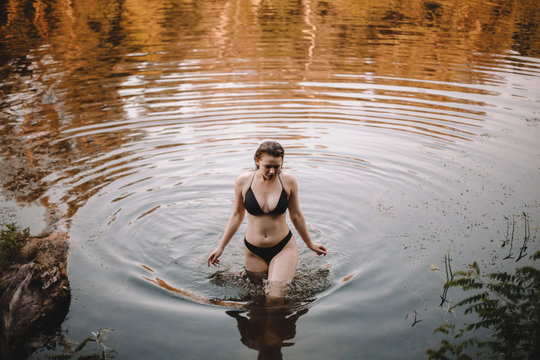 Young woman in bikini walking in lake