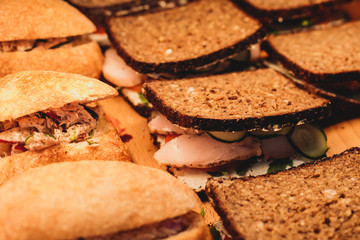 Beautifully decorated catering banquet table with different food snacks and appetizers with sandwich, on corporate christmas birthday kids party event or wedding celebration