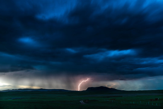 Dark cloudy sky with lightning in the middle hitting the ground