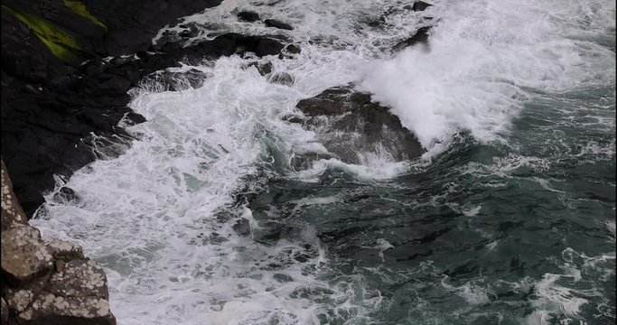 Waves breaking on coastal cliffs of Scotland.