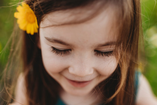 Close up portrait of little girl with eyes closed and smiling