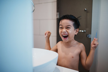 Boy combing hair in front of mirror
