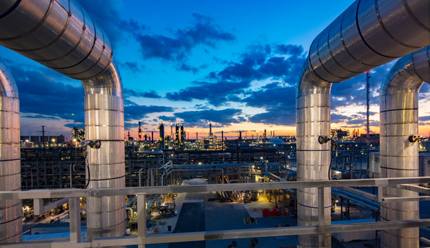 Sunset as viewed through pipe in refinery