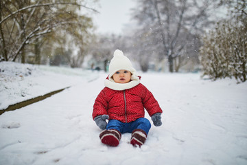 Fototapeta na wymiar Happy smiling baby girl sitting in snow