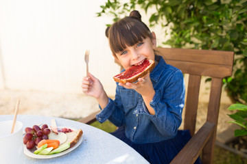 Girl Eating Bread With Raspberry Jam