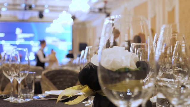 A waiter sets the table in a restaurant before customers arrive, and uses fine cutlery and glasses. Concept of: catering, design, romantic dinners. Luxurious catering background. Celebration idea