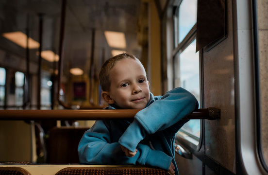Young boy sat on a train smiling
