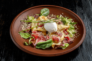 Diet menu. Salad with chopped steak, poached eggs, pancakes, green salad. Sprinkled with grated cheese.