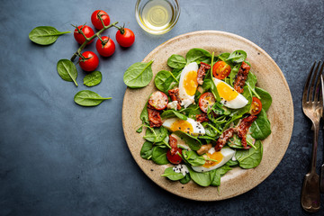 Salad with spinach, sun-dried tomatoes and eggs. Healthy home made food. Concept for a tasty and healthy meal. Top view. Copy space.