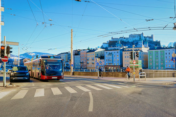 Naklejka na ściany i meble Cityscape with car and bus on street road Salzburg Castle
