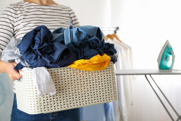 Young woman hold basket with dirty clothes, space for text