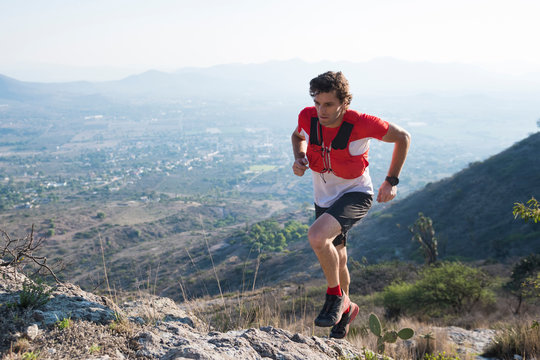Male trail runner navigating rocky terrain he climbs the arid mountains near el Arenal, hidalgo, Mexico