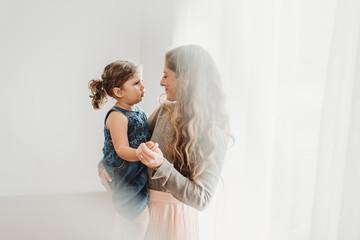 Mid level view of mother holding young daughter in studio