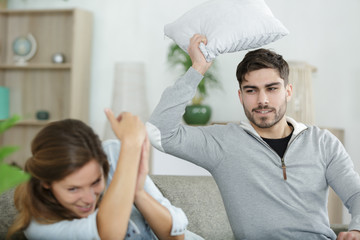 picture showing happy couple having pillow fight