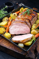 Traditionell gebratender dry aged Kalbsrücken mit Karotten und Kartoffel angeboten als closeup auf...