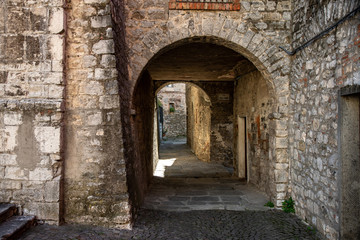 Fototapeta na wymiar Narrow street passing through stone arches in the medieval town of Roccalbegna, in the Grosseto Maremma.