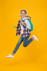 Always in motion. Energetic cheerful teen listening music. Stylish schoolgirl going to school. Girl little fashionable girl carry backpack. School daily life. Happy carefree child. School and leisure
