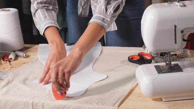 Young tailor working with sewing pattern, close up video. Lifestyle, free time, spare time