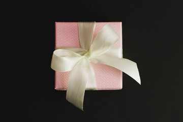 Pink gift box on black background.