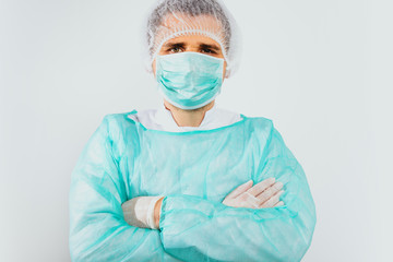 Man dressed in a green surgical apron and a mask on his face on a white background. Medical and pharmaceutical concept. Doctor or surgeon. Preparation for surgery, treatment of people.
