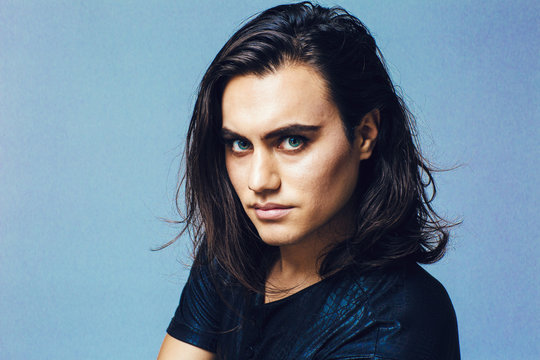 Portrait Of A Young Man With Long Hair In Studio