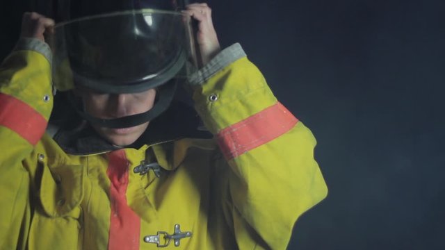 Firefighter putting a helmet on