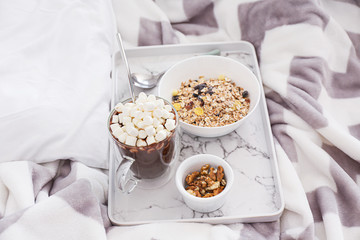 Tray with tasty breakfast on bed