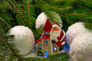 Santa Claus on a house near the branches of a Christmas tree. Background for New Year and Christmas.