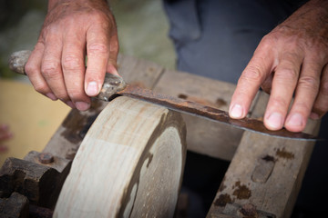 Fototapeta na wymiar Sharpening knife on old grindstone wheel