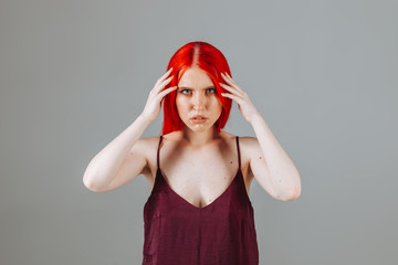 Girl touches her red long hair