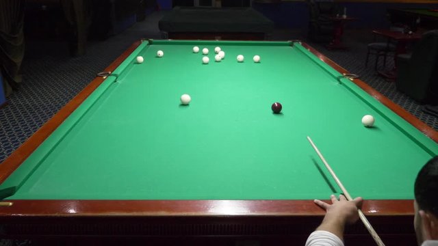 billiards. Close-up. man hand with cue and white ball on a green pool table. copy space