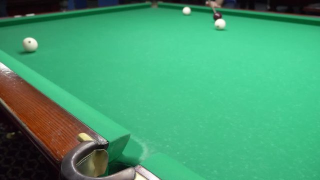 billiards. Close-up. man hand with cue and white ball on a green pool table. copy space