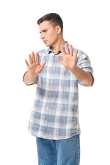 Portrait of handsome young man rejecting something on white background