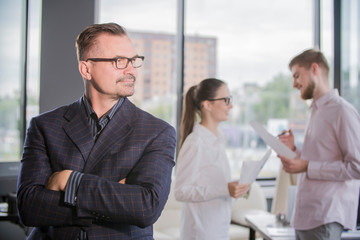successful businessman in the office on the background of colleagues