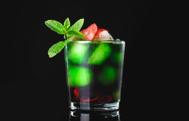 Glass of tasty cocktail on dark background