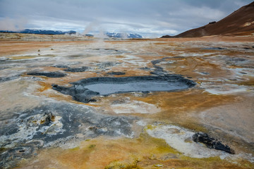 Boiling mudpots in the geothermal area Hverir and cracked ground around, Iceland in summer. Myvatn region, North part of Iceland