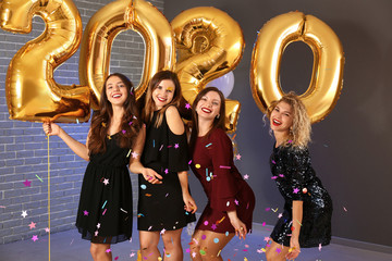Beautiful young women with balloons at Christmas party