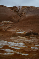 Fototapeta na wymiar Red clay hill in the geothermal area Hverir, Iceland in summer. Myvatn region, North part of Iceland