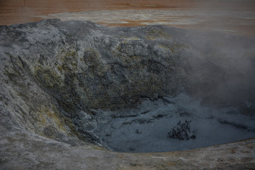 Sculptures of boiling grey mud in Hverir, Krafla geothermal area, Iceland in summer, closeup.