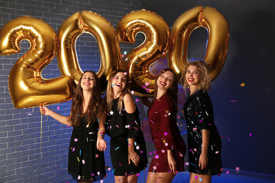 Beautiful young women with balloons at Christmas party