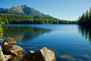 Autumn Strbske pleso lake  with stones in the front on a sunny day in High Tatras National Park,...