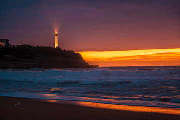 Fototapeta premium Biarritz lighthouse at Beach of Little House of Love in Biarrtiz in a beautiful sunset. France