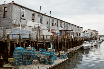 Commercial fishing wharf with stacks of lobster traps in the Old Port Harbor district of Portland, Maine.  