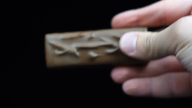 Chocolate bar in hand of man in front of black background