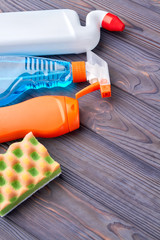 House cleaning chemicals on dark wooden background. Spring cleaning and household chores. Space for...