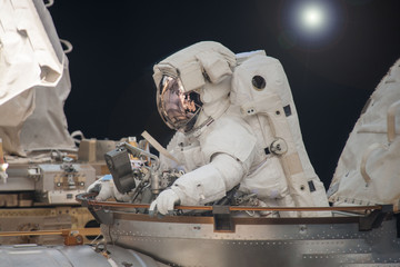 Astronaut in a spacesuit. At the space station. Engaged in maintenance. Elements of this image were...