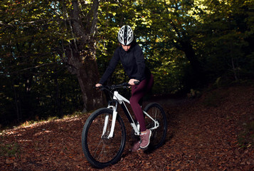 Fototapeta premium Female cyclist driving in the wood