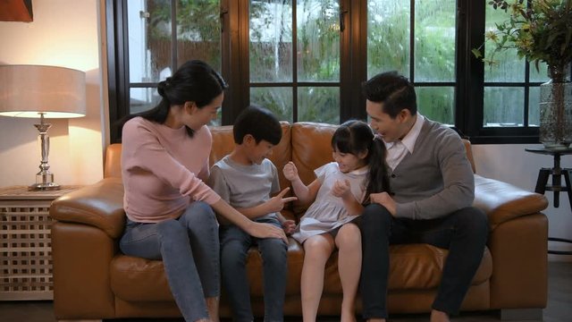 Holiday concept. The family is playing on the sofa in the living room. 4k Resolution.