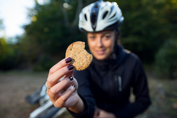 Female cyclist eating integral biscuit